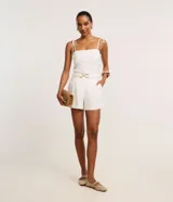 Short de sastrería de cintura alta, confeccionado en crepé de color blanco, con bolsillos laterales y cinturón elástico incluido con hebilla metálica dorada.