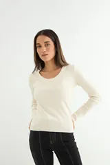 Sweater de punto fino en color beige, con cuello redondo y mangas largas, de corte ajustado al cuerpo.