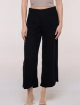 Pantalón crop de lino y rayón, con diseño wide leg de corte holgado, estampado tropical de hojas en tonos verde, azul y marrón sobre fondo blanco. Cuenta con pretina trasera elastizada y bolsillos delanteros.