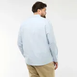 Camisa de corte recto confeccionada en tejido oxford de algodón, color celeste claro. Presenta cuello abotonado, cierre frontal con botones y mangas largas con puños abotonados.
