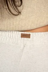 Pantalón de corte recto y holgado, confeccionado en tejido liviano color arena con textura jaspeada. Presenta cintura elástica con cordón interno, bolsillos frontales tipo parche y un calce fluido.
