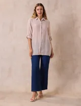 Camisa larga de rayón, con cuello clásico, cierre frontal con botones y mangas regulables con presilla. Presenta un diseño holgado con tajos laterales en el ruedo.