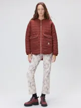 Campera capitoneada reversible de color bordó, con diseño liviano, cuello redondo, cierre frontal y dos bolsillos delanteros con solapa.