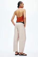 Pantalón cargo de tiro alto y corte holgado con piernas globo, confeccionado en mezcla de algodón y nylon. Cuenta con cintura elástica, bolsillos laterales al bies y bolsillos tipo parche con costuras decorativas visibles en la parte delantera.