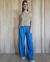 Pantalón de algodón color arena, de corte recto y holgado, con cintura elástica y detalle de costuras horizontales decorativas en la parte inferior de las piernas.