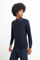 Sweater de punto color beige con cuello polo blanco y mangas largas.