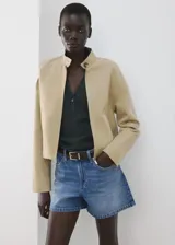 Short de denim azul de tiro medio, con diseño recto y clásico de cinco bolsillos, presillas para cinturón y cierre frontal con botón y cremallera.