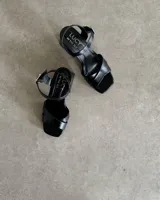 Sandalias de cuero color bronce, con taco cuadrado y tiras cruzadas en el empeine.