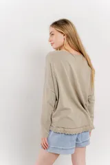 Remera color arena de corte holgado y mangas largas.