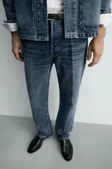 Jeans de mezclilla de algodón, tiro medio, con pierna recta y ajuste ligeramente holgado. Presenta efecto lavado y cierre frontal de botonadura.