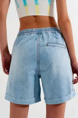 Short de jean celeste con cintura elastizada, cordón de ajuste y roturas.