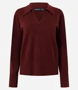 Suéter de punto color celeste, con cuello polo y escote en V. Presenta mangas largas con puños acanalados y terminación de basta también acanalada, ofreciendo un calce cómodo y versátil.