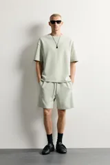 Bermuda estilo jogger de ajuste relajado, confeccionada en tejido interlock de algodón. Cuenta con cintura elástica ajustable con cordón, bolsillos frontales de vivo y diseño liso.