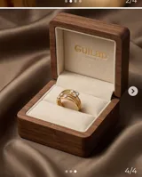 Anillo de acero con baño de oro, compuesto por tres bandas entrelazadas, decorado con tres pequeñas circonias engastadas.