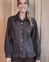 Sobrecamisa de pana color marrón oscuro, con cuello camisero, cierre frontal de botones y detalle de volado en el ruedo. Presenta mangas largas con puños y bolsillos frontales aplicados.