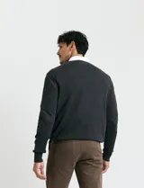 Sweater de punto color ladrillo con cuello en V y mangas largas.