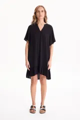 Vestido corto negro de viscosa, con escote en V, mangas cortas y volado en el ruedo.