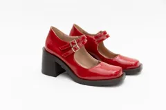 Guillerminas de cuero charol negro con punta cuadrada, taco ancho y correa sobre el empeine con doble hebilla dorada.