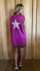 Vestido corto de algodón color fucsia, con cuello redondo y sin mangas. Presenta una gran estrella beige en la espalda y un borde marrón en el dobladillo.
