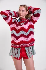 Sweater tejido a crochet de lana merino con diseño de rayas en zigzag de colores, cuello redondo, mangas largas amplias y calce holgado.