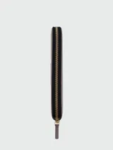 Billetera Marc Jacobs The Continental Wallet de cuero negro, con cierre perimetral de cremallera metálica dorada y tirador de cuero. Interior con múltiples ranuras para tarjetas, compartimentos para billetes y monedero con cierre.