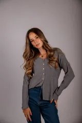 Blusa color beige de morley, con cuello en V y abotonada al frente.