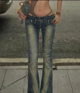 Jean de tiro bajo con efecto desgastado y costuras decorativas que realzan la silueta. Presenta un corte ajustado en la cadera y muslos con una leve apertura acampanada en la botamanga, incorporando un cierre frontal visible.