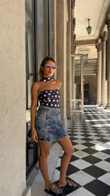 Top estilo pañuelo (bandana) de color marrón oscuro con estampado de lunares blancos. El diseño es strapless con un nudo central fruncido y se ata al cuello como un halter.