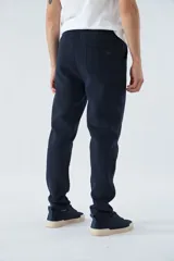 Pantalón deportivo de invierno, corte clásico con bolsillos laterales y cintura elástica con cordón ajustable. Presenta logo estampado y detalle en goma.