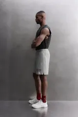 Pantalones cortos de algodón color gris, con cintura elástica ajustable con cordón y parche con logo. Incluye bolsillos laterales y un bolsillo trasero. Presenta bandas laterales a tono, bordado y estampado combinado a contraste en el delantero y la espalda, y aberturas laterales en el bajo.