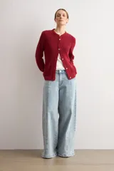 Chaqueta tejida de punto acanalado en color azul marino, con cuello redondo, cierre frontal de botones metálicos y dos bolsillos delanteros aplicados.