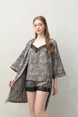 Bata de pijama tipo kimono con estampado animal print en tonos beige y negro, de silueta relajada, con cruce frontal y lazo regulable en la cintura. Tiene mangas amplias y largo por encima de la rodilla.