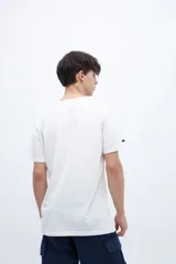 Remera blanca de algodón con cuello redondo y manga corta. Estampado fotográfico en el pecho con texto.