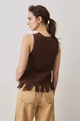 Blusa tejida sin mangas en color marrón chocolate, con textura acanalada, cuello redondo y detalle de flecos en el ruedo.
