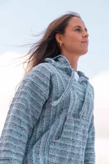 Buzo con capucha de tejido tipo yamba en tonos celeste, gris y negro.