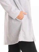 Cardigan largo de tejido de punto suave, color gris, con cuello con caída fluida, mangas largas con hombros caídos y bolsillos laterales discretos.