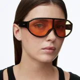 Lentes de sol estilo deportivo con diseño envolvente de lente panorámica única. Presentan una montura negra y lentes de color naranja con protección UV.