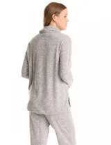 Buzo de tejido suave con cuello volcado ajustable mediante cordones con punteras metálicas. Presenta mangas largas con puños decorados con botones metálicos, hombros caídos y ruedo redondeado con aberturas laterales.