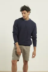 Sweater de punto fino azul con cuello redondo y terminaciones elásticas en canalé.