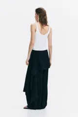 Musculosa blanca de punto acanalado, con escote en U pronunciado tanto en el frente como en la espalda y tirantes finos.