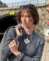 Collar con dije grande de bronce con forma orgánica y textura rugosa, suspendido de un cordón negro. Incluye cordones intercambiables.