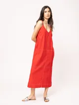 Vestido largo color crudo de lino, con silueta recta, escote en V, breteles anchos, detalle de elástico en la espalda y tajos laterales.