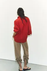 Camisa de corte oversize confeccionada en popelín de algodón, con cuello solapa, manga larga con puños y cierre frontal de botones.