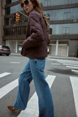 Chaqueta acolchada de cuello redondo y manga larga, con cierre frontal de botones y dos bolsillos delanteros de plastrón. Presenta un diseño de costuras en forma de rombos.