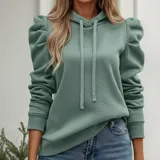 Buzo tipo hoodie de color azul marino, confeccionado en tejido suave con diseño de mangas princesa fruncidas en los hombros. Presenta capucha con cordones ajustables y puños elásticos.