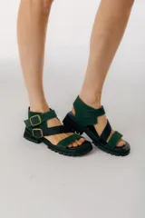 Sandalias con plataforma color verde y negro, con tiras de cuero y hebillas metálicas.