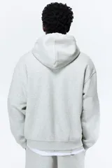 Campera con capucha en felpa de peso medio color gris claro, con interior cepillado suave, cierre y bolsillos delanteros, puños y bajo en punto acanalado. Corte holgado.