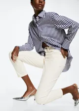 Jeans de tiro alto con corte mom-fit, confeccionados en tejido de algodón estilo vaquero. Presentan diseño de cinco bolsillos, trabillas para cinturón y cierre frontal con cremallera y botón.