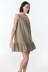 Vestido corto negro de tirantes finos con volados en el ruedo.