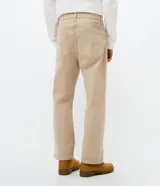 Pantalón de sarga de algodón con acabado vintage, corte recto y ajuste cómodo. Presenta cierre frontal con botón y cremallera, pasadores para cinturón y bolsillos funcionales en la parte delantera y trasera.